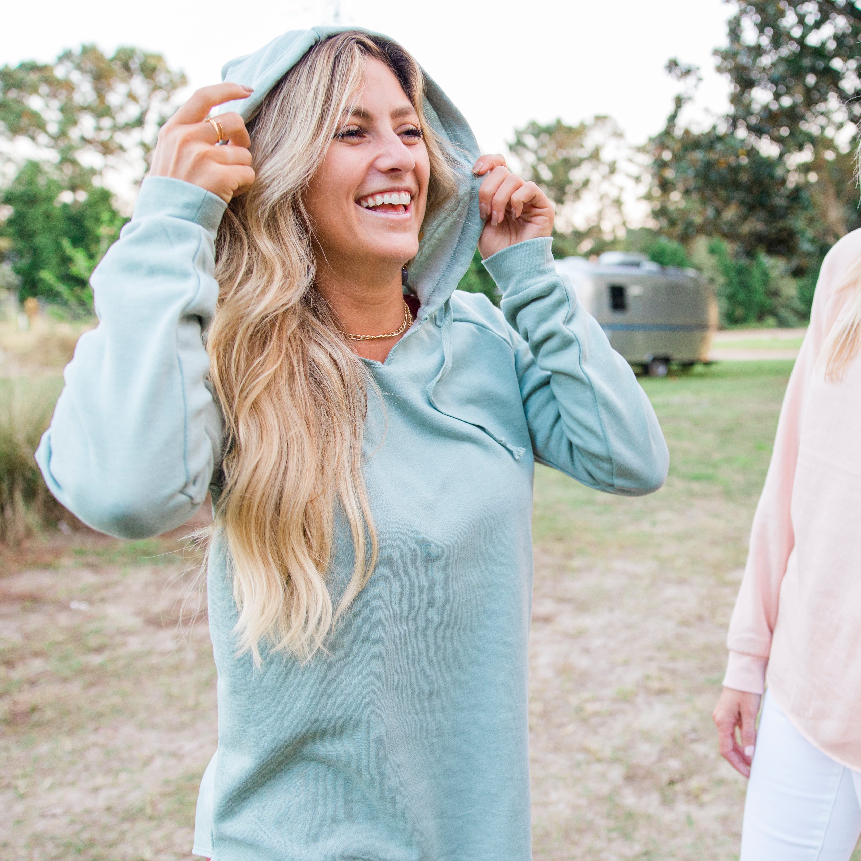 Blonde woman wearing a blue pullover hoodie from Independent Trading Company and Port City Apparel in Wilmington North Carolina.